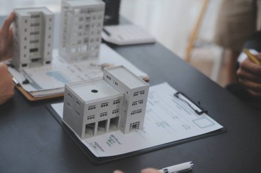 Emlakçı ve satış yöneticisi takım analiz Satılık Kiralık kira sözleşmesinin fiyatlandırma için ipotek kredi teklif ve ev sigortası ile ilgili anlaşma, Satın almak.