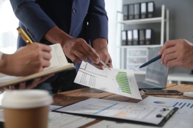 İş ekibi toplantısı yeni bir başlangıç projesi üzerinde çalışıyor, verileri tartışıyor ve analiz ediyor çizelgeler ve grafikler. Dijital tablet, hesap makinesi, dizüstü bilgisayar kullanımı, iş finans ve muhasebe kavramı.