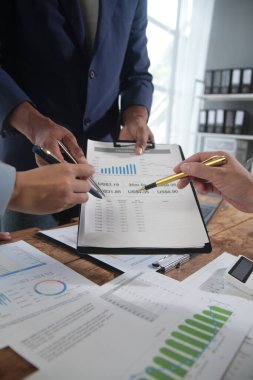 İş ekibi toplantısı yeni bir başlangıç projesi üzerinde çalışıyor, verileri tartışıyor ve analiz ediyor çizelgeler ve grafikler. Dijital tablet, hesap makinesi, dizüstü bilgisayar kullanımı, iş finans ve muhasebe kavramı.