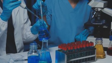 Laboratuvarda cam şişeler tutan bilim adamı
