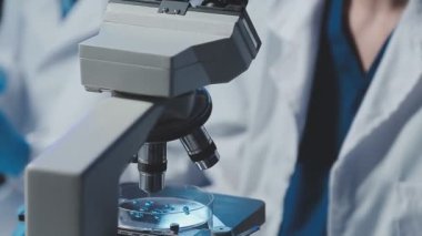 Laboratuvarda mikroskop kullanarak bilim adamına yakın çekim yap.