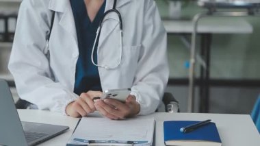 Tabletli doktor ve hasta klinikte oturuyor..