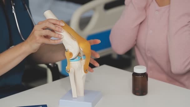 의사는 사무실에서 인간의 무릎을 검사하고 있습니다 — 비디오