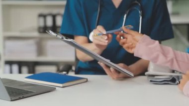 Doktor ofisinde bir pano tutuyor.