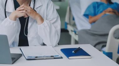 Beyaz önlüklü doktor ofisinde masasında çalışıyor..