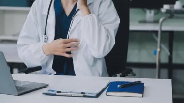 Hastane ofisinde çalışan beyaz önlüklü doktor.