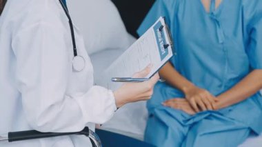 Üniformalı genç bayan doktor elinde bir not panosu tutuyor.