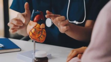 Doktor steteskopla kalp tutuyor.