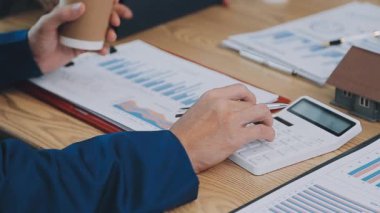 İş adamı masadaki mali verileri hesaplamak için hesap makinesi kullanıyor. iş kavramı.