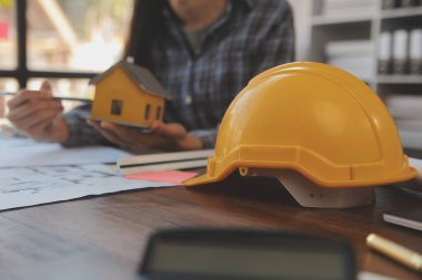 A team of construction engineers talks to managers and construction workers at the construction site. Quality inspection, work plan, home and industrial building design project