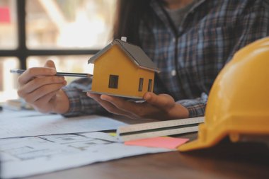 A team of construction engineers talks to managers and construction workers at the construction site. Quality inspection, work plan, home and industrial building design project