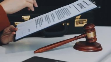 Yargıç Tokmak ve yargıcın hukuk kitabı ahşap masada.