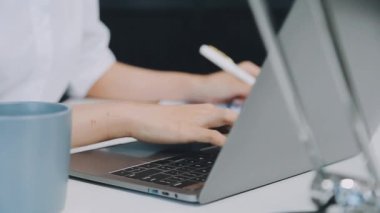 Ofiste bir dizüstü bilgisayar kullanan kadın