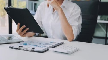 Ofiste tablet bilgisayar kullanan bir kadın..