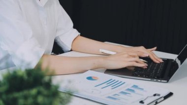 Modern ofiste bilgisayar ve finansal verilerle çalışan iş kadını