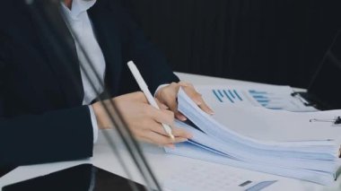 Takım elbiseli genç işadamı elinde belgeleri tutuyor..