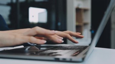 Laptop bilgisayarı olan genç bir kadın ev ofisinde çalışıyor.