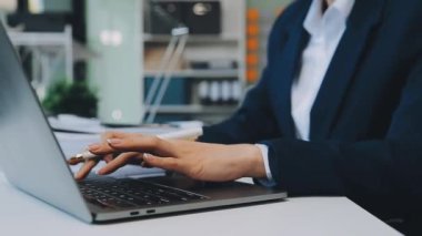 İş kadını bilgisayarın klavyesinde el yazısı yazıyor.