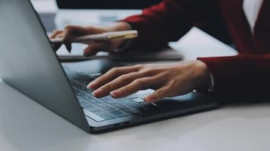 Klavyede yazan ve dizüstü bilgisayarda yazan iş kadınını kapat