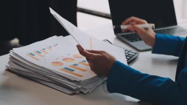 İş adamları ofiste dizüstü bilgisayarla mali istatistikleri tartışıyor