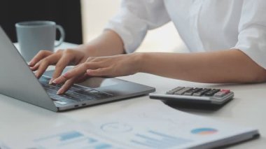 Ofisteki masada dizüstü bilgisayar ve kredi kartı kullanan iş kadını, online alışveriş kavramı.