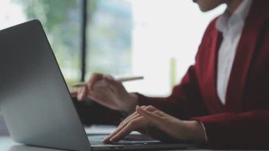 İş kadını ofiste dizüstü bilgisayar kullanıyor..