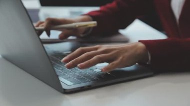 Yakın plan - İş yerinde dizüstü bilgisayar kullanan iş kadını.