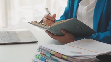 İş kadını ofisteki not defterine yazıyor.