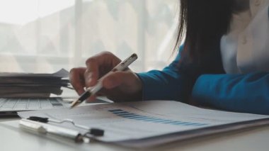 Masadaki dizüstü bilgisayarda çalışan Asyalı genç iş kadını.