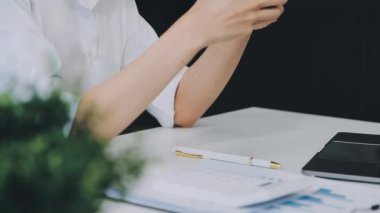 Evde dizüstü bilgisayar ve akıllı telefonla çalışan genç bir kadın.