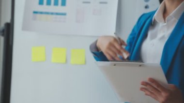 Ofisteki genç kadın elinde bir panoyla.