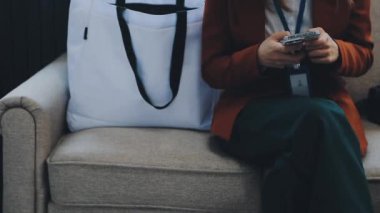 Dizüstü bilgisayarı olan bir kadın koltukta oturuyor.