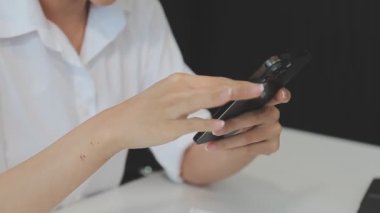 Ofiste cep telefonu kullanan genç bir kadın.