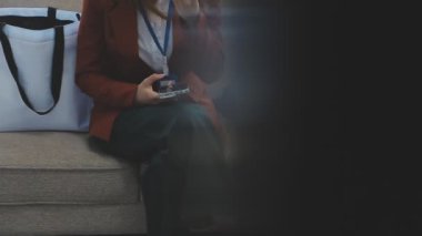 Kanepede oturan çantalı kadın.