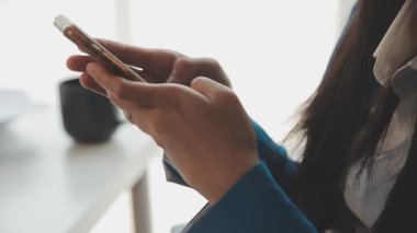 Ofiste akıllı telefonu tutan kadın.