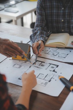 A team of construction engineers talks to managers and construction workers at the construction site. Quality inspection, work plan, home and industrial building design project