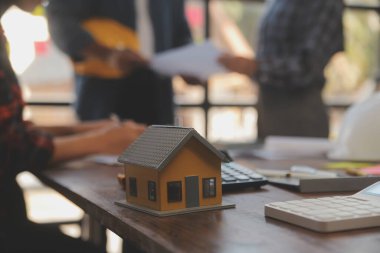 A team of construction engineers talks to managers and construction workers at the construction site. Quality inspection, work plan, home and industrial building design project