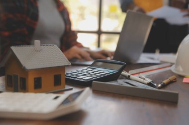 A team of construction engineers talks to managers and construction workers at the construction site. Quality inspection, work plan, home and industrial building design project