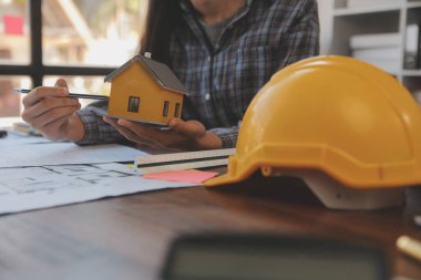 A team of construction engineers talks to managers and construction workers at the construction site. Quality inspection, work plan, home and industrial building design project