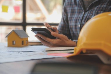 A team of construction engineers talks to managers and construction workers at the construction site. Quality inspection, work plan, home and industrial building design project