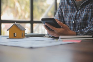 A team of construction engineers talks to managers and construction workers at the construction site. Quality inspection, work plan, home and industrial building design project