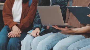 Dizüstü bilgisayarı ve tableti olan bir grup genç öğrenci