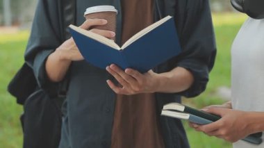 Genç Asyalı kız öğrenci parkta kitap okuyor, eğitim ve öğrenim kavramı.