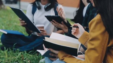 Kampüste kitap ve not defteri olan bir grup öğrenci..