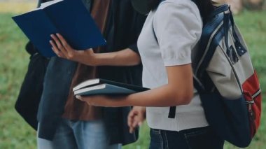 Öğrenciler kütüphanede çalışıyor. Kitapları ve tableti olan genç bir adam ve kadın..