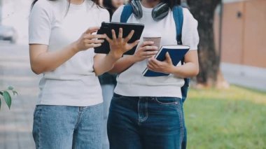 Genç Asyalı öğrenciler birlikte tablet bilgisayar kullanıyorlar..