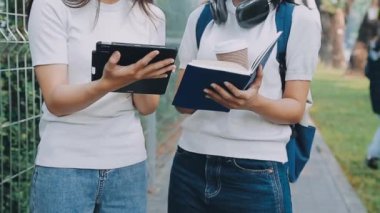 Ellerinde kitap ve tabletle birlikte eğitim gören iki genç öğrenci. Eğitim kavramı.