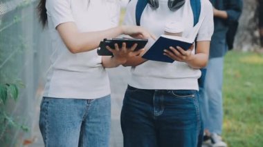 Genç öğrenciler üniversitede açık havada okuyorlar.