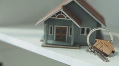 Ahşap masada anahtarı olan model bir ev.