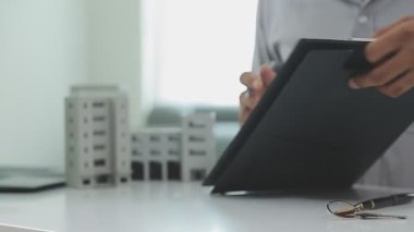 Emlakçı dairenin arka planında anahtarları gösteriyor..